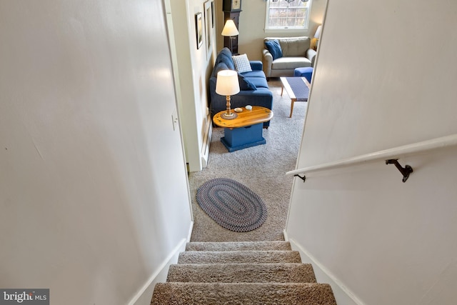 staircase featuring carpet flooring and baseboards