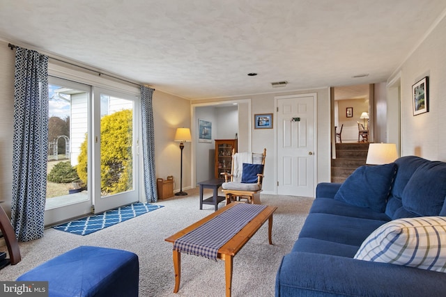 living room with carpet, visible vents, a textured ceiling, and stairs