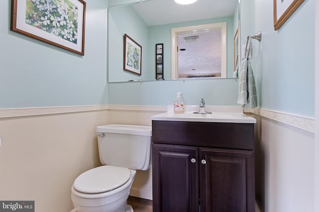 bathroom with visible vents, vanity, and toilet