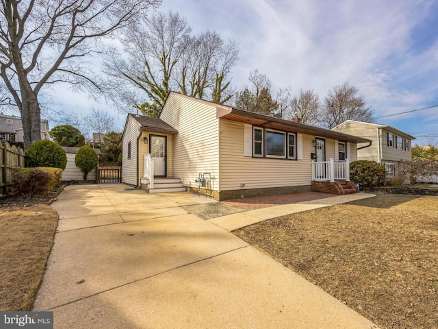 view of front of home featuring concrete driveway and fence