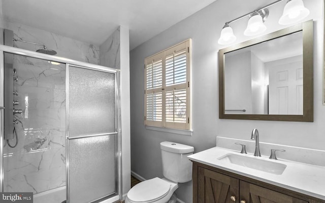 bathroom with toilet, vanity, and a marble finish shower