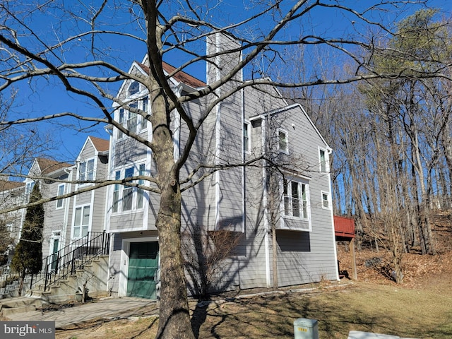 view of property exterior featuring concrete driveway, an attached garage, and a balcony