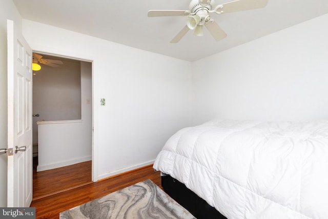 bedroom featuring wood finished floors, a ceiling fan, and baseboards