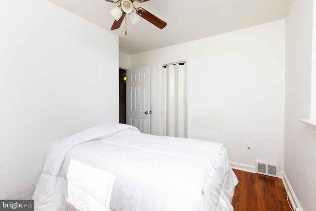 bedroom featuring baseboards, visible vents, ceiling fan, and wood finished floors