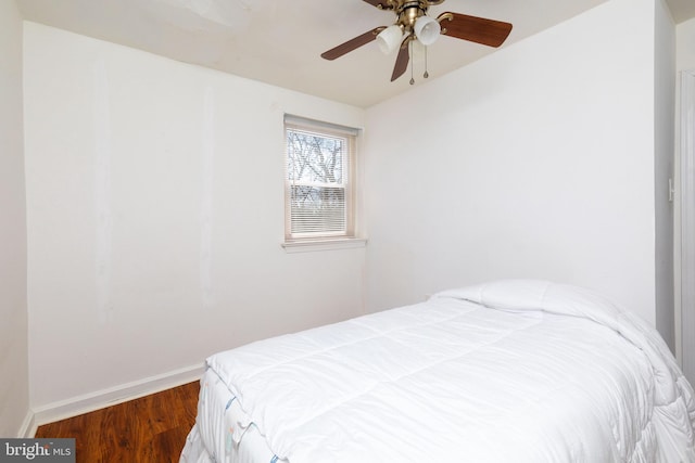 bedroom featuring ceiling fan, baseboards, and wood finished floors