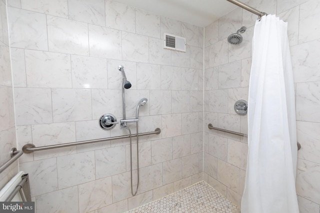 full bathroom with visible vents and a tile shower