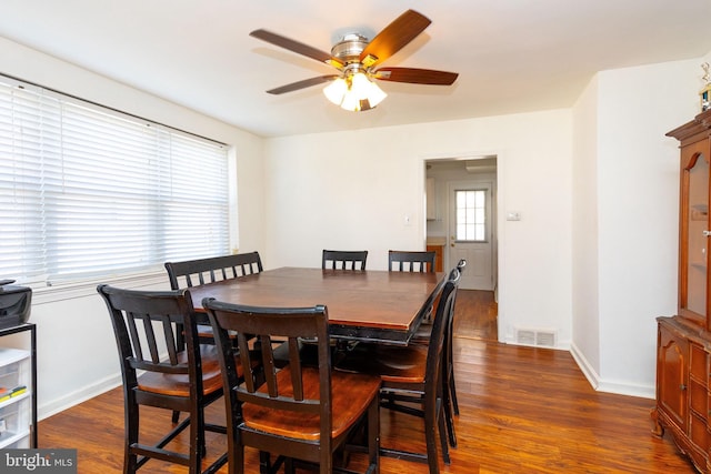 dining area with dark wood-style floors, visible vents, baseboards, and a ceiling fan