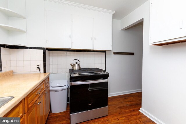 kitchen featuring light countertops, tasteful backsplash, dark wood-type flooring, and range with gas stovetop