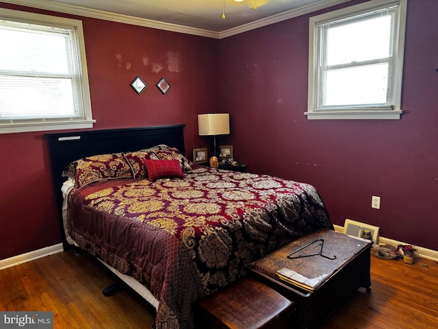 bedroom featuring baseboards, crown molding, and hardwood / wood-style flooring