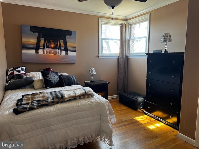 bedroom featuring crown molding, baseboards, and hardwood / wood-style floors