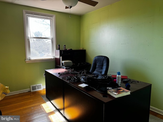 home office with visible vents, baseboards, wood finished floors, and a ceiling fan