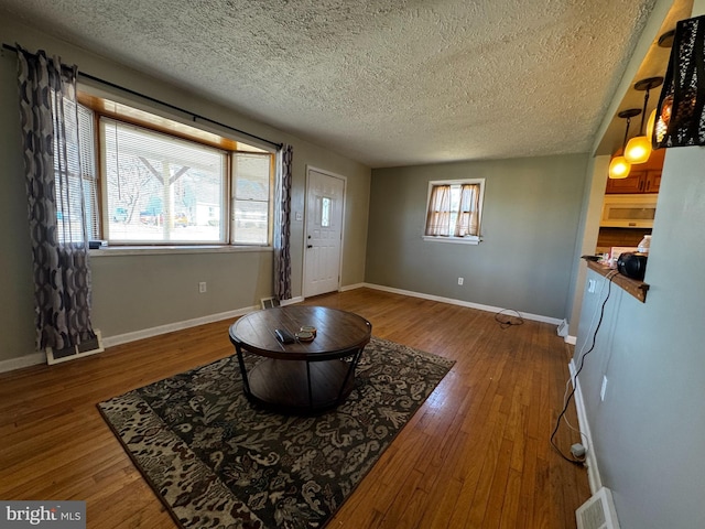 foyer featuring visible vents, baseboards, and hardwood / wood-style flooring