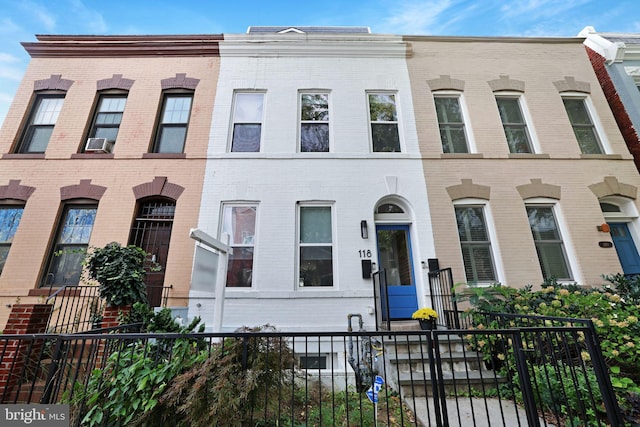 view of property featuring a fenced front yard and brick siding