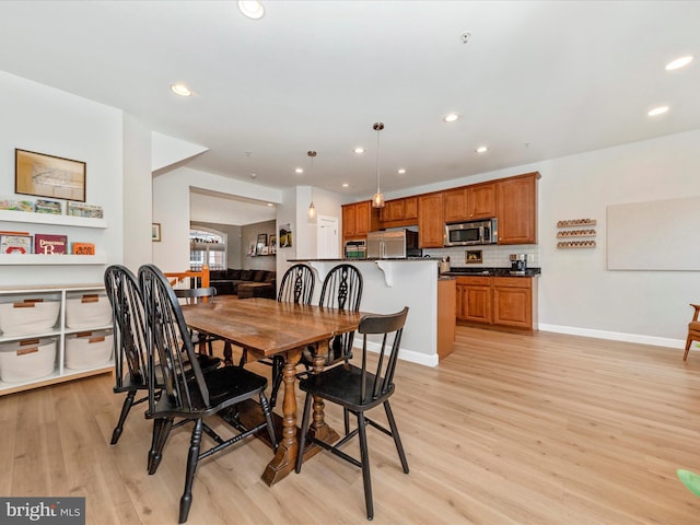 dining room with baseboards, light wood-type flooring, and recessed lighting