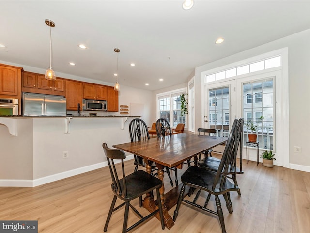 dining room with recessed lighting, baseboards, and light wood finished floors