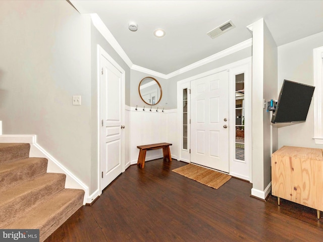 entryway with visible vents, ornamental molding, wood finished floors, baseboards, and stairs