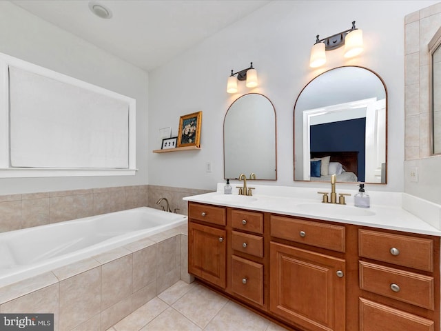 bathroom with double vanity, tile patterned flooring, a sink, and a bath