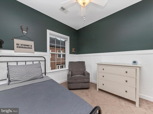 bedroom with carpet floors, wainscoting, and visible vents