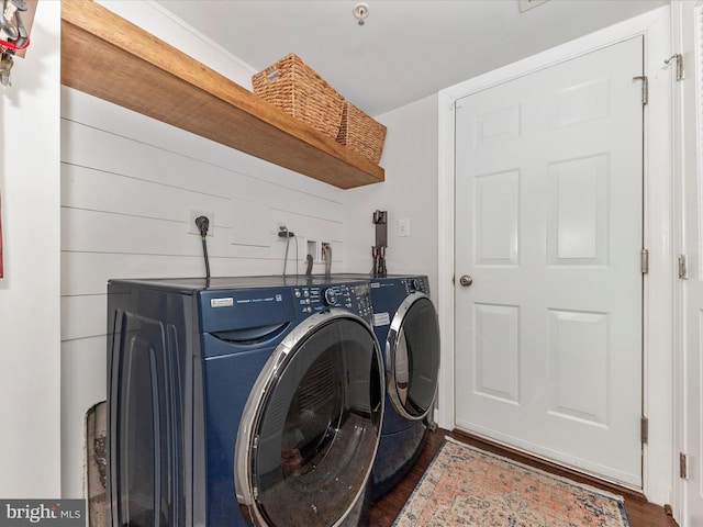 clothes washing area with laundry area, dark wood-style floors, and washing machine and clothes dryer