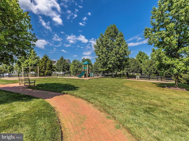 community play area featuring fence and a lawn