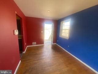 unfurnished room with wood finished floors and baseboards