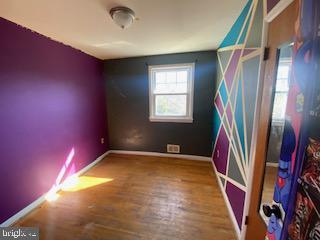 empty room featuring baseboards and wood finished floors