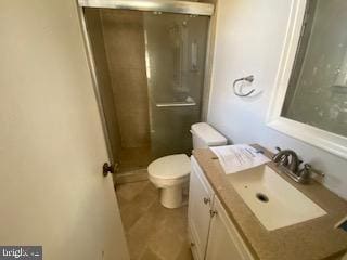 full bathroom with toilet, a stall shower, and vanity