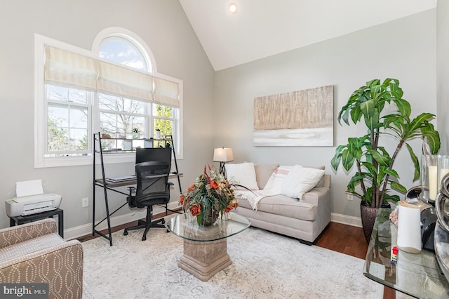 office space with high vaulted ceiling, baseboards, and wood finished floors