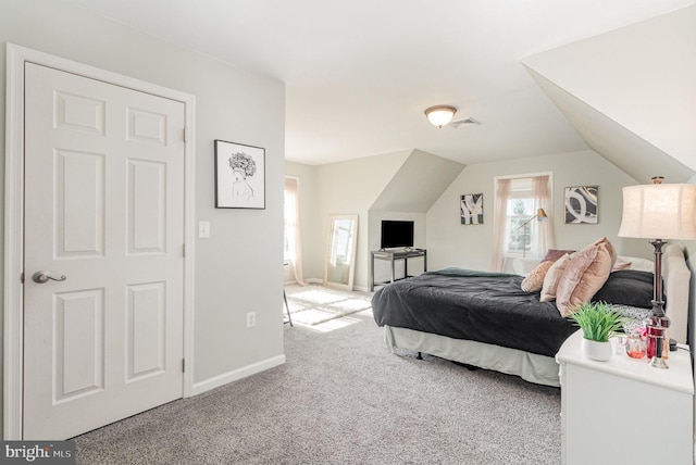 carpeted bedroom with vaulted ceiling, visible vents, and baseboards