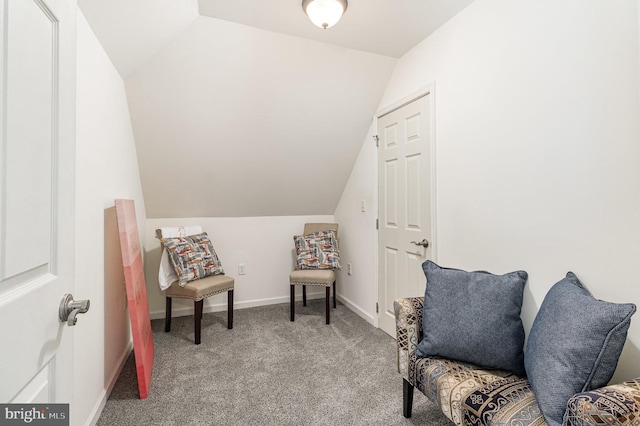 living area with baseboards, light carpet, and vaulted ceiling