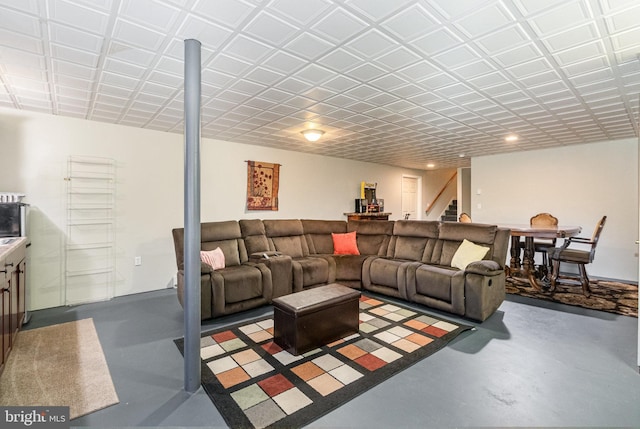 living area featuring stairway and concrete flooring