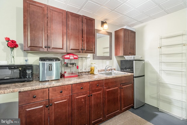 kitchen featuring a sink, an ornate ceiling, freestanding refrigerator, black microwave, and light countertops