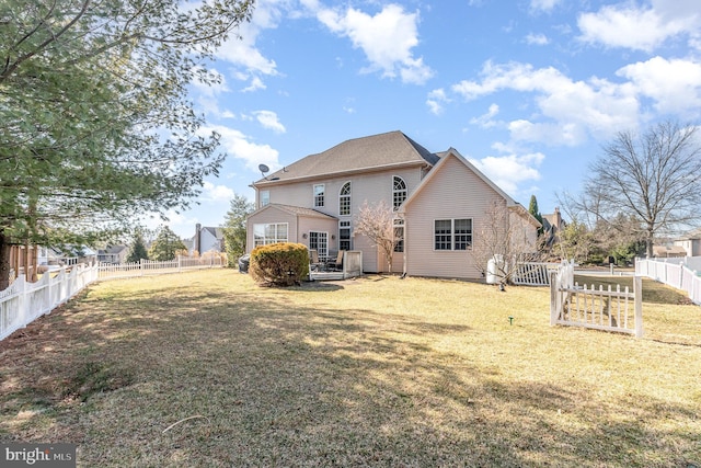 back of property with a lawn and a fenced backyard