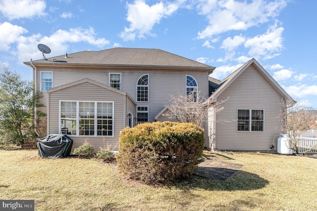 rear view of house featuring a yard and fence