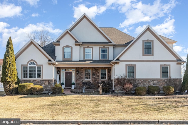 view of front of house with stucco siding, stone siding, roof with shingles, and a front lawn