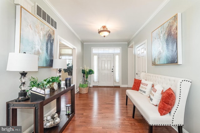 entrance foyer with visible vents, ornamental molding, baseboards, and wood finished floors