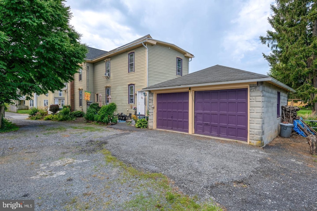 view of front facade featuring a garage, stone siding, aphalt driveway, and a shingled roof