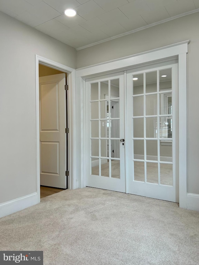 entryway featuring french doors, carpet flooring, and baseboards