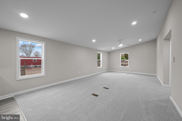 carpeted spare room with lofted ceiling, baseboards, visible vents, and recessed lighting