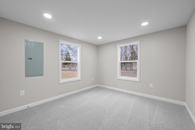 spare room with carpet, electric panel, baseboards, and recessed lighting