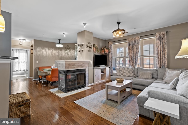 living room featuring baseboards, wood finished floors, and a tile fireplace