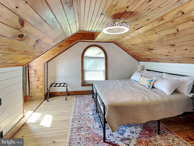 bedroom featuring wooden ceiling, light wood-style flooring, and wood walls