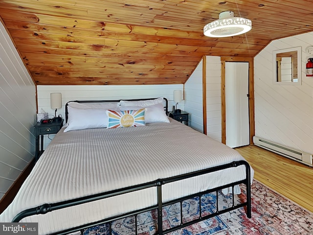 bedroom featuring wooden walls, a baseboard heating unit, wood ceiling, vaulted ceiling, and wood finished floors