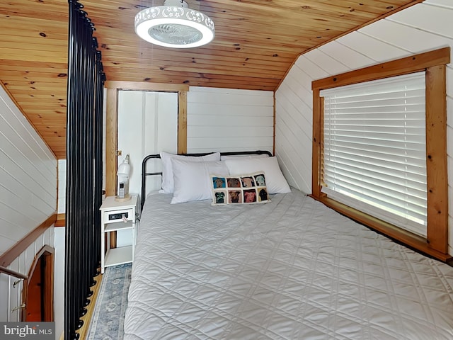 bedroom featuring lofted ceiling, wooden walls, and wood ceiling