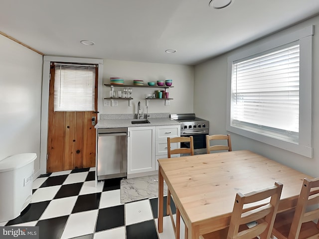 kitchen featuring a sink, tile patterned floors, white cabinets, stainless steel appliances, and open shelves