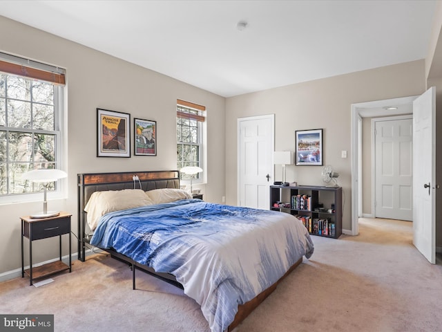 bedroom with light colored carpet and baseboards