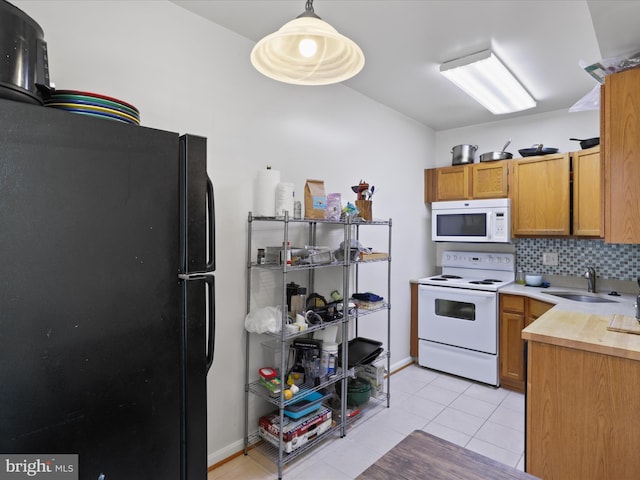 kitchen with white appliances, light tile patterned floors, a sink, light countertops, and backsplash