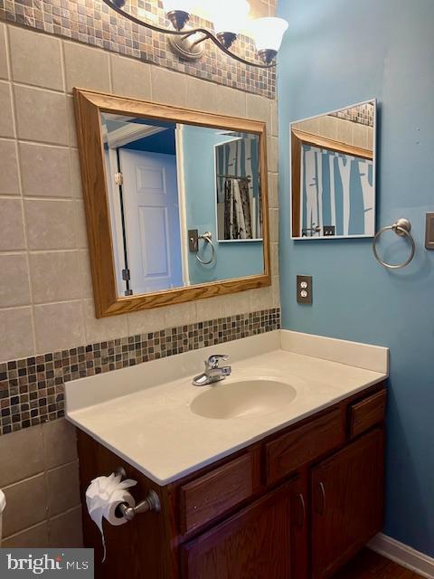 bathroom with decorative backsplash and vanity