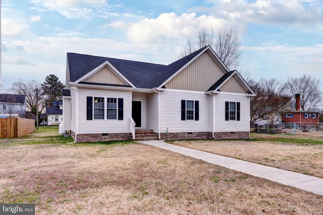 view of front of house with crawl space, a shingled roof, a front yard, and fence