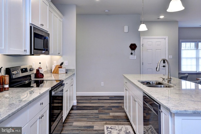 kitchen featuring beverage cooler, an island with sink, a sink, appliances with stainless steel finishes, and white cabinetry